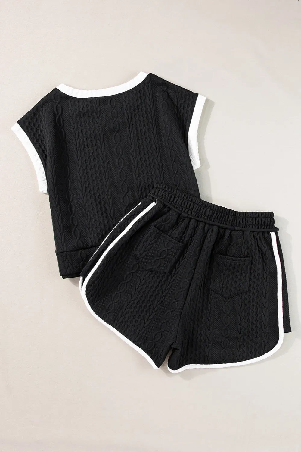 Black textured knit two-piece set with white contrast trim on sleeves, hem and sides