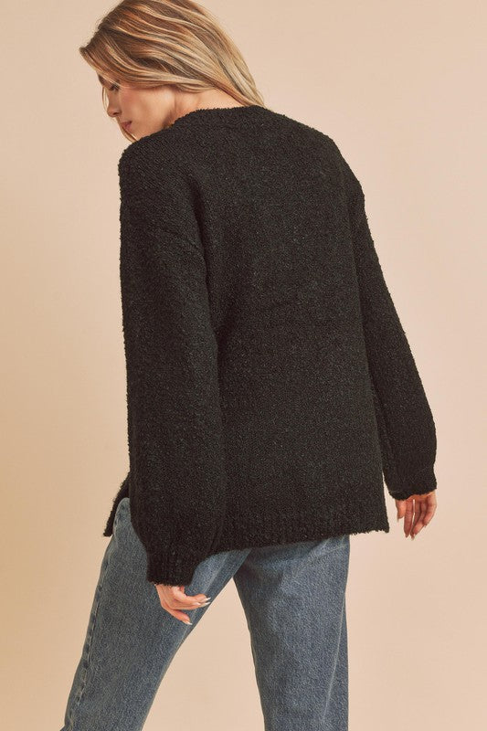 Black fuzzy knit sweater with side slit hem and mock neck by Aemi + Co