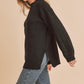 Black fuzzy knit sweater by Aemi + Co with relaxed fit and side slits