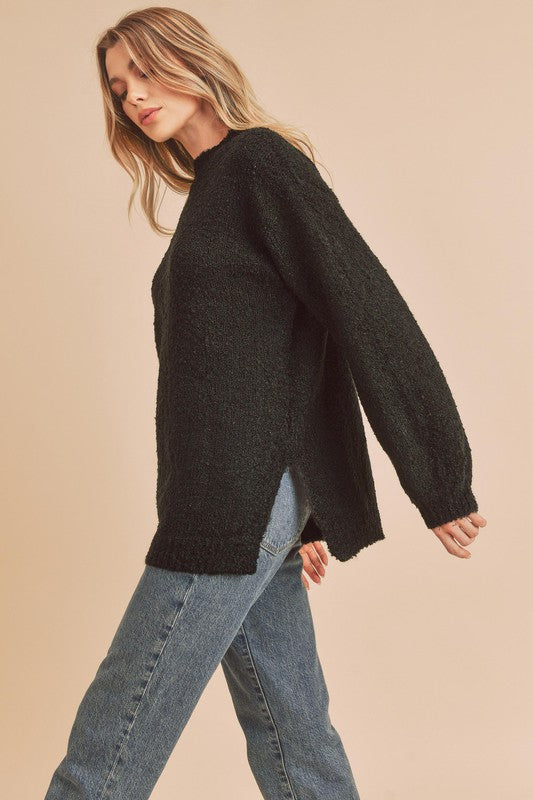 Black fuzzy knit sweater by Aemi + Co with relaxed fit and side slits