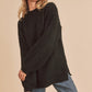 Black oversized fuzzy knit sweater with side slit hem by Aemi + Co