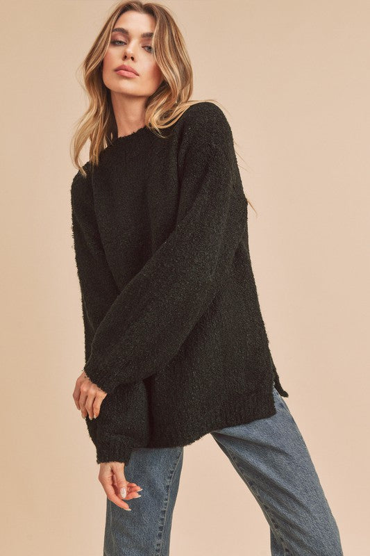 Black oversized fuzzy knit sweater with side slit hem by Aemi + Co