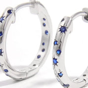 Silver starry huggie earrings with blue zircon gemstones