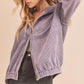 Woman wearing a purple corduroy jacket against a beige background