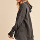 Woman wearing a dark gray hoodie on a beige background