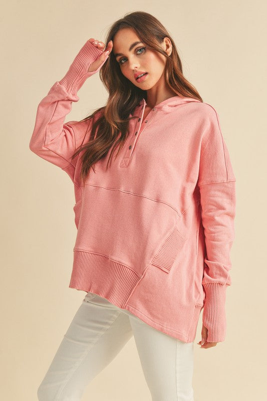 Woman wearing a pink hoodie against a beige background