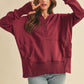 Woman wearing a burgundy hoodie with a beige background