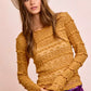 Mustard yellow ruffled sweater with white wide-brimmed hat
