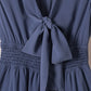 Tie-front mini dress in soft blue with smocked waist and back bow