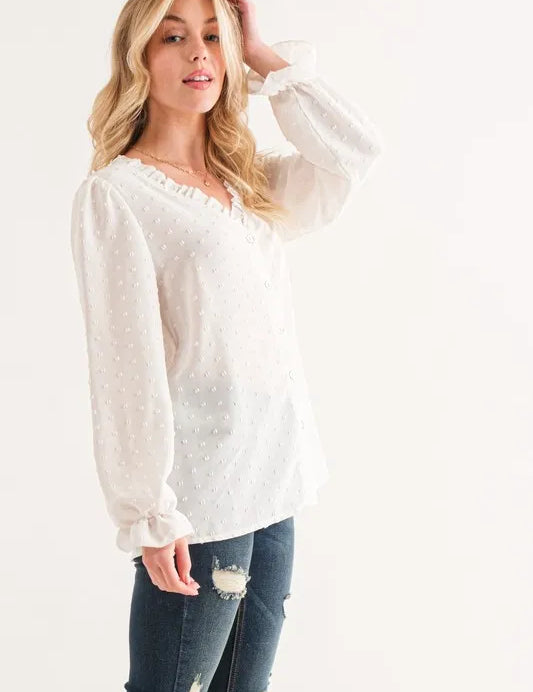 White sheer polka dot blouse with ruffled neckline and long sleeves