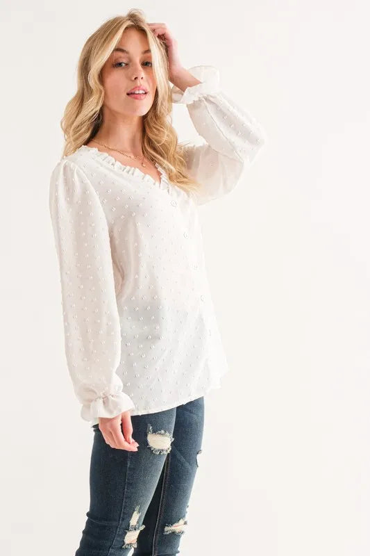 White sheer polka dot blouse with ruffled neckline and long sleeves