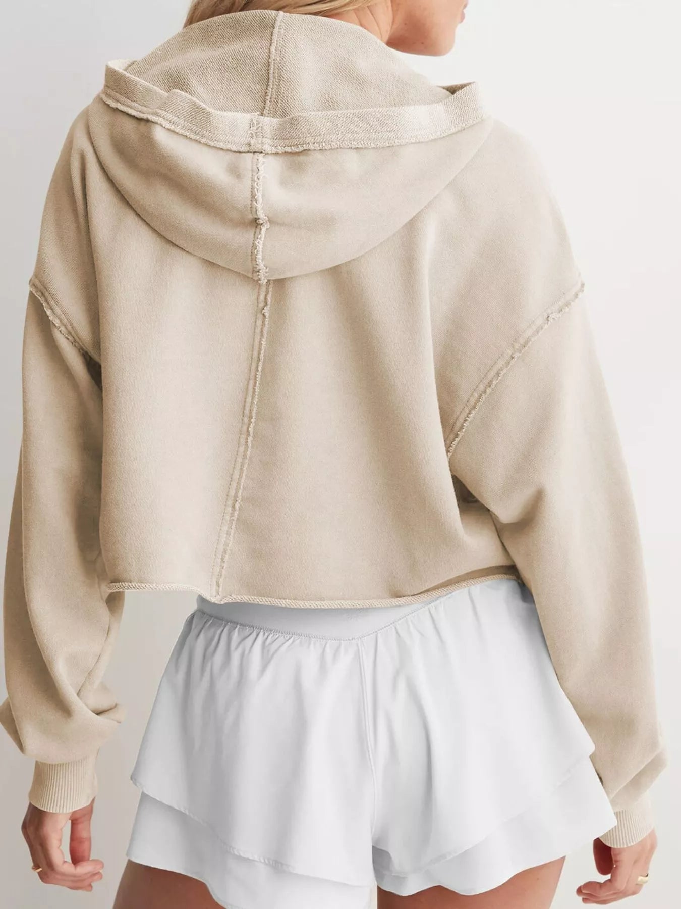 Exposed seam dropped shoulder beige cropped hoodie with distressed look