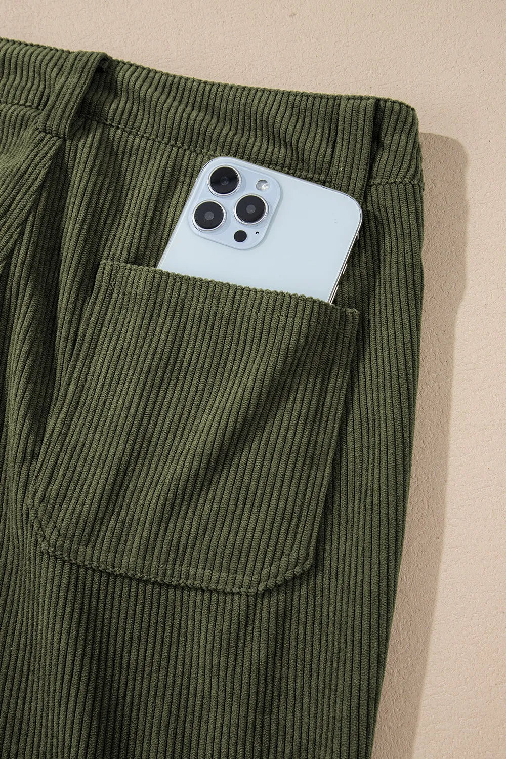 Olive green women’s high-waist corduroy pants with phone in pocket