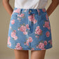 Vibrant pink rose floral print on medium-wash blue denim mini skirt