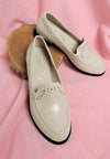 Cream-colored studded faux leather loafers with black rubber soles