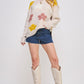 Cream-colored embroidered cowboy boots with leaf details and block heel