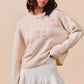 Cream-colored SO ME knit sweater with pink embroidered bows