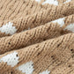Tan and white diamond-textured knit blanket on women’s puff sleeve baggy sweater
