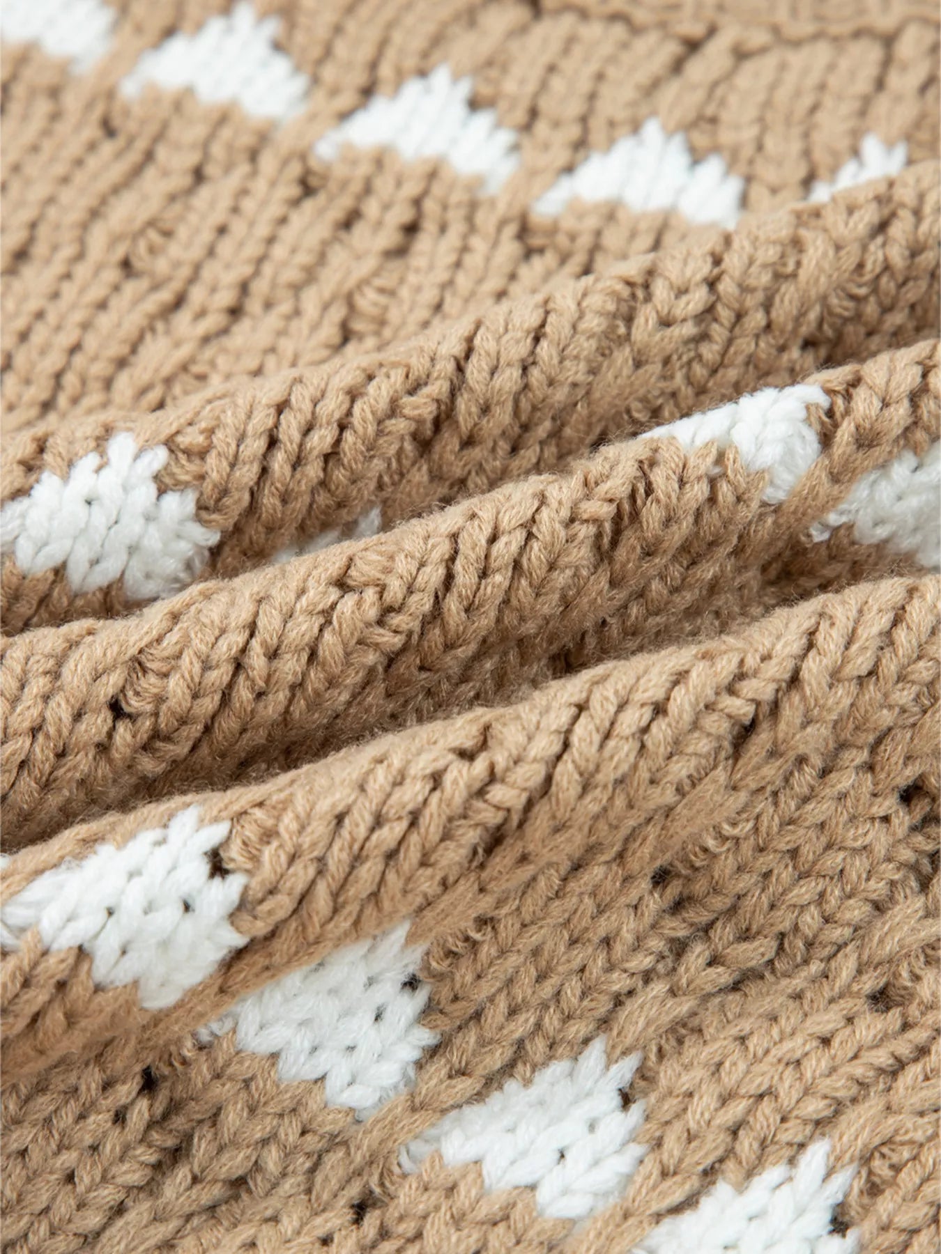 Tan and white diamond-textured knit blanket on women’s puff sleeve baggy sweater