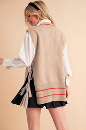 Beige knit Aemi + Co poncho vest with red white striped trim and tassels