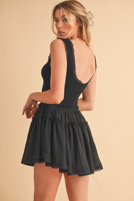 Black sleeveless Love Drop Waist mini dress with lace-trimmed back and ruffled skirt
