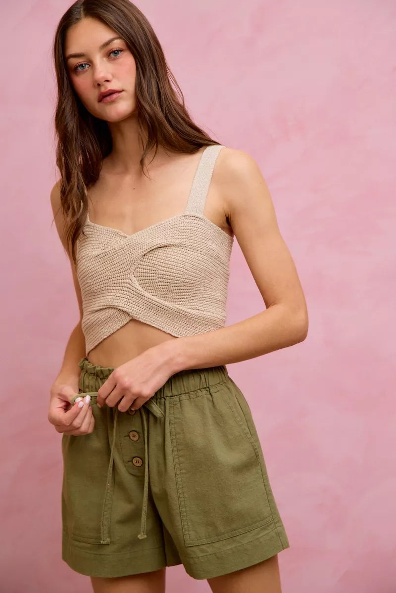 Beige crocheted crop top with thin straps on twill shorts