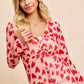Pink long-sleeved BiBi button-down shirt with red heart print and ruched front