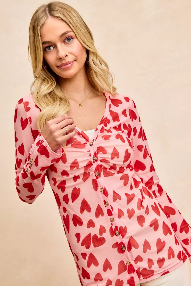 Pink long-sleeved BiBi button-down shirt with red heart print and ruched front