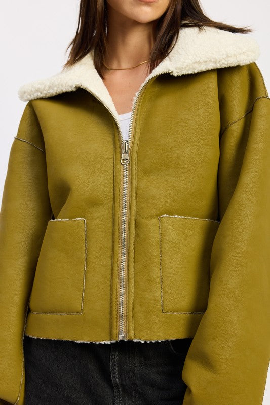 Olive green shearling-lined reversible suede bomber jacket with zipper and flap pockets