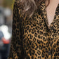 Woman in leopard-print button-up long sleeve shirt with black tan spots