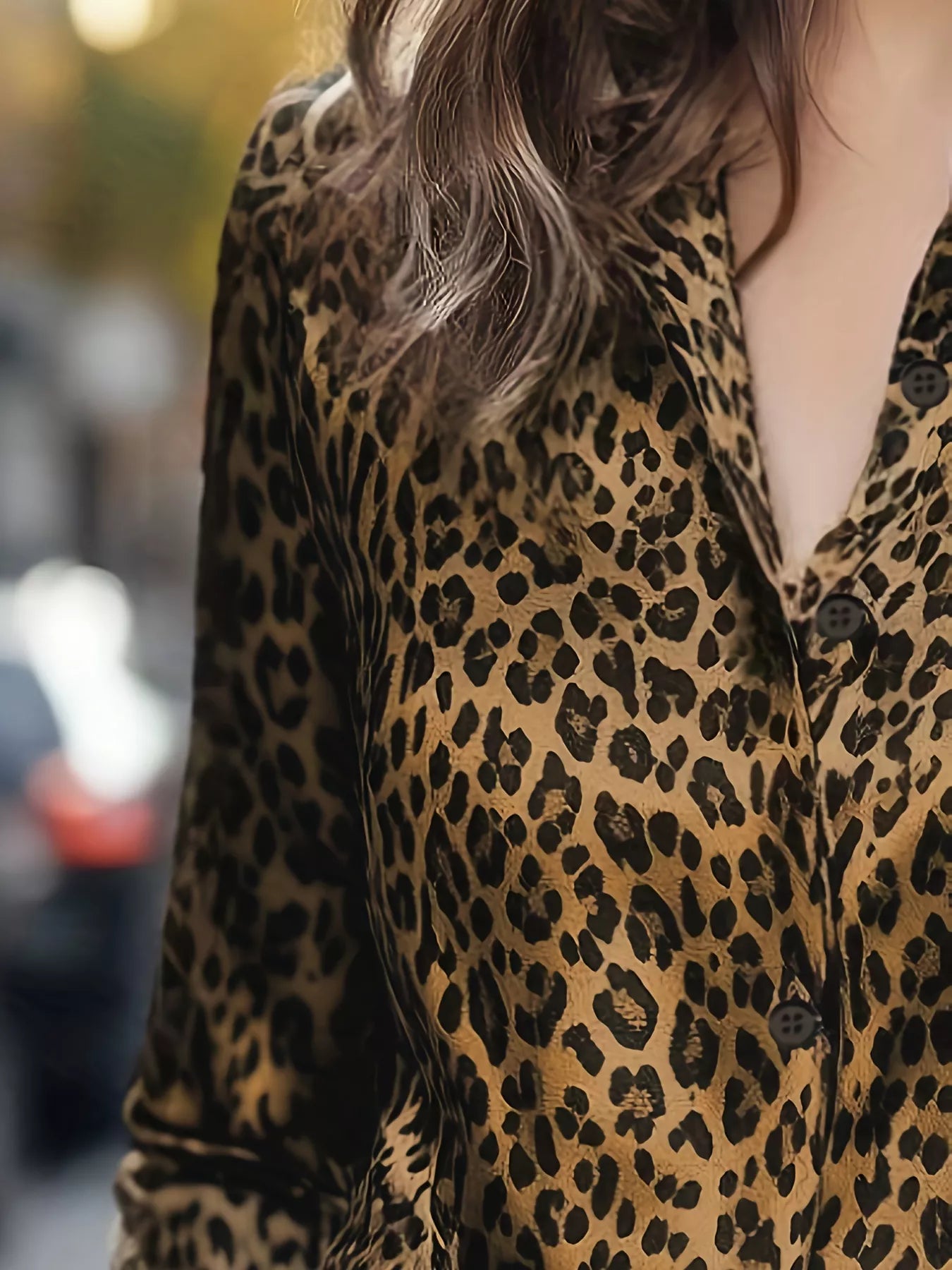 Woman in leopard-print button-up long sleeve shirt with black tan spots