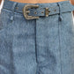 Blue denim belt with ornate silver buckle on wide leg trousers