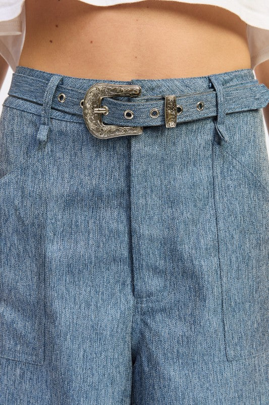 Blue denim belt with ornate silver buckle on wide leg trousers