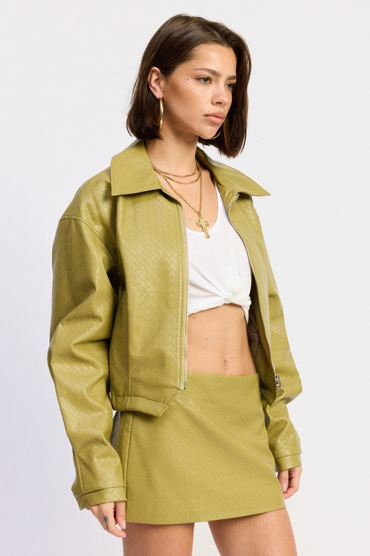 Olive green satin mini skirt with gold hardware and layered necklaces