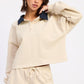 Beige cropped polo shirt with navy collar and long sleeves