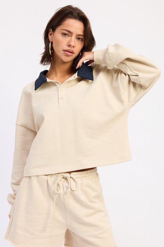 Beige cropped polo shirt with navy collar and long sleeves