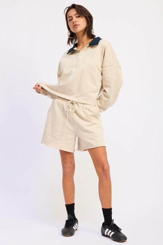 Beige oversized rugby sweatshirt with navy collar and drawstring shorts