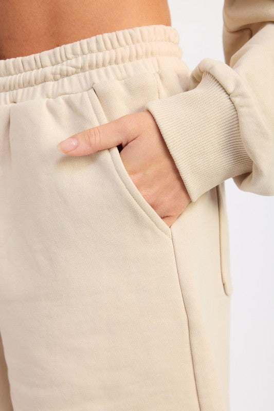 Beige French terry shorts with pockets, elastic waistband, ribbed cuffs