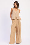 Beige v-neck sleeveless vest with button closure on Emory Park linen pants