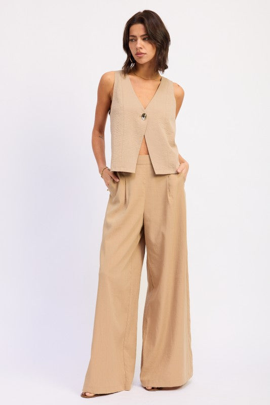 Beige v-neck sleeveless vest with button closure on Emory Park linen pants