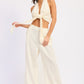 Cream-colored satin double gauze halter neck crop top with tied knot and wide-leg trousers