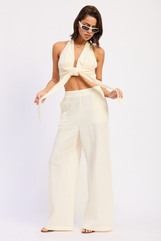 Cream-colored double gauze halter neck crop top with front knot and wide-leg trousers