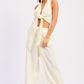 Cream-colored satin halter crop top with knot and cutouts, wide-leg trousers