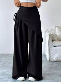 Daverri wrap-front wide-leg pants in black with draped asymmetrical design and side tie detail