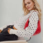Red leather shoulder bag with black butterfly pattern on Daverri sweater