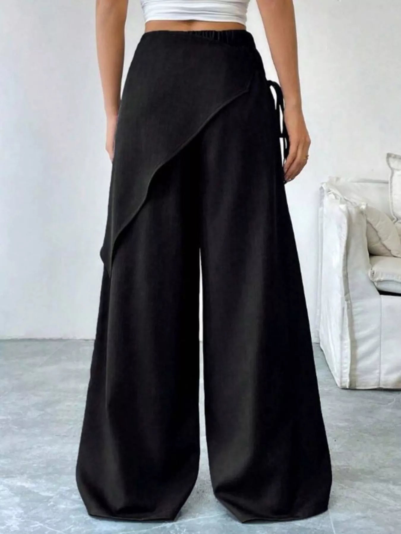 Daverri wrap-front wide-leg pants in black with draped asymmetrical front