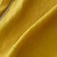 Golden-yellow silk fabric texture on Daverri wide-leg pants