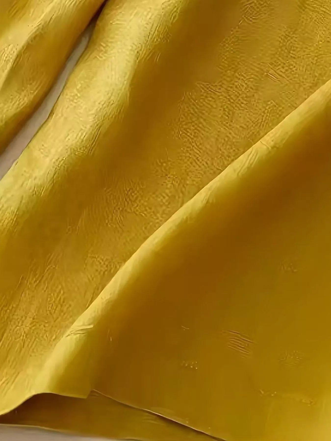 Golden-yellow silk fabric texture on Daverri wide-leg pants