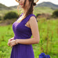 Woman in vibrant purple Davi & Dani smocked bodice ruffle jumpsuit