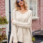 Beige v-neck ribbed knit sweater with long sleeves and slit hem